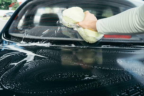 スポンジで車を洗う手 - 写真・画像