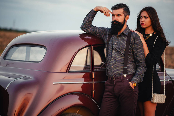 Stijlvol bebaarde man en mooie brunette vergadering in een luxe auto - Foto, afbeelding