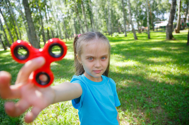 Menina brincando com um fidget spinner
 - Foto, Imagem