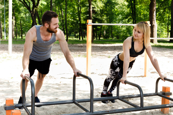 Young sportive woman and bearded man doing push-ups exercises. - Fotoğraf, Görsel