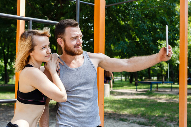 Young caucasian couple making selfie photo while doing fitness e - Photo, Image
