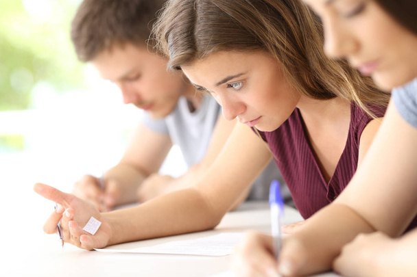 Student reading a cheating sheet during an exam - Fotoğraf, Görsel
