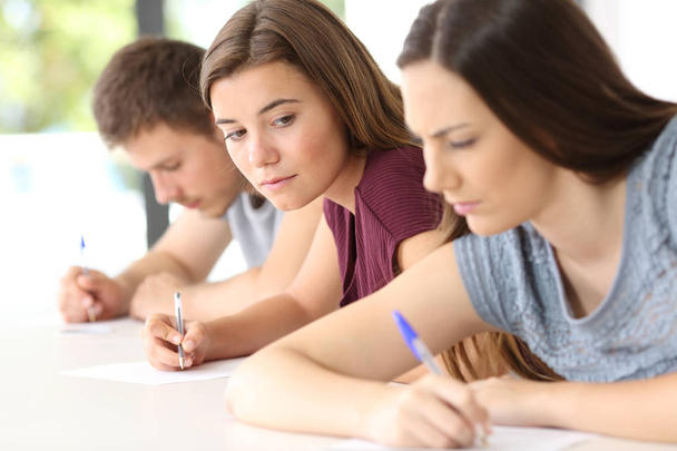 Student trying to copy an exam of a classmate - Zdjęcie, obraz