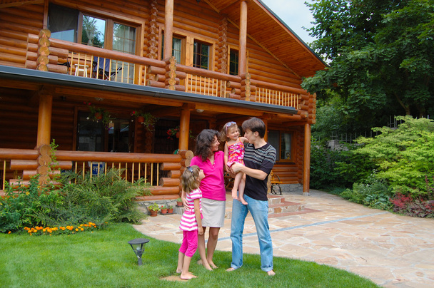 Happy smiling family near wooden house - Foto, immagini