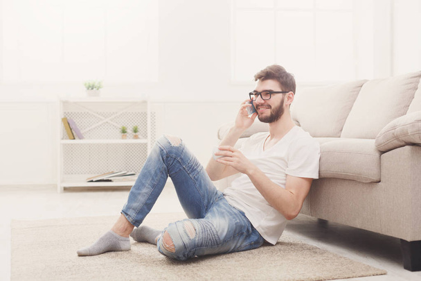 Чоловік в окулярах вдома з мобільним
 - Фото, зображення