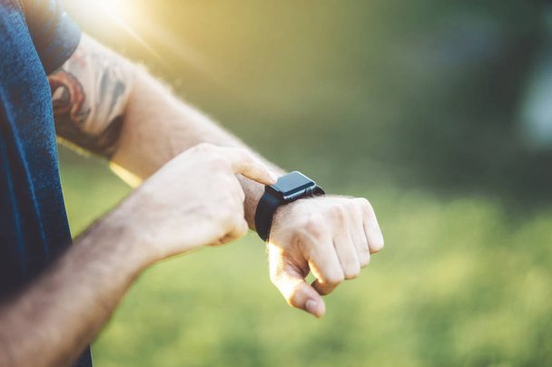 Close up van jonge running man tracking verbrand calorieën op elektronische slimme horloge - Foto, afbeelding