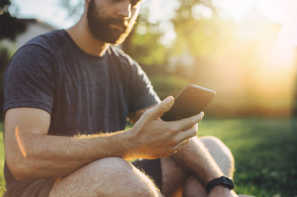 Close up of man checking burned calories on smart phone application and smart watch - Valokuva, kuva