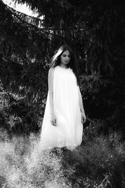 Fantasma cubierto con una sábana blanca fantasma en un camino rural. Grainy imagen texturizada
 - Foto, Imagen