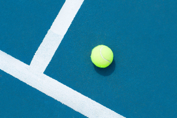 Tennis ball on tennis court with white line - Foto, afbeelding