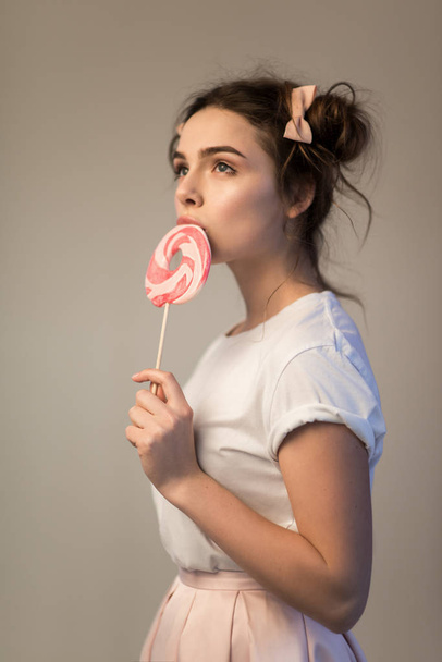 Beautiful brunette girl with candy in her hands - Foto, Imagem