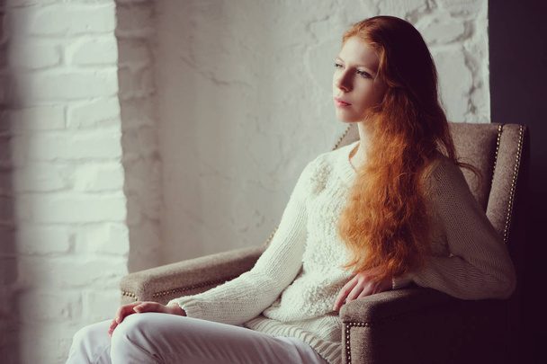 close up indoor portrait of adorable thoughtful young redhead woman with freckles and long hair - Фото, зображення