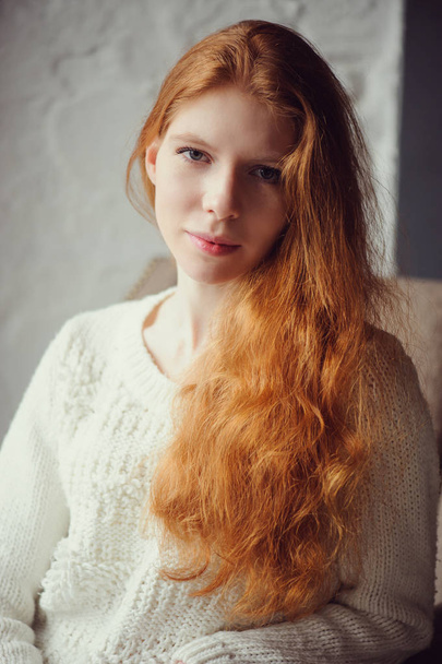 close up indoor portrait of adorable thoughtful young redhead woman with freckles and long hair - Fotó, kép