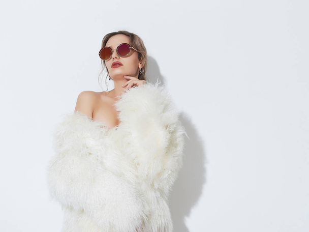 sexy woman in fur and sunglasses - Foto, afbeelding