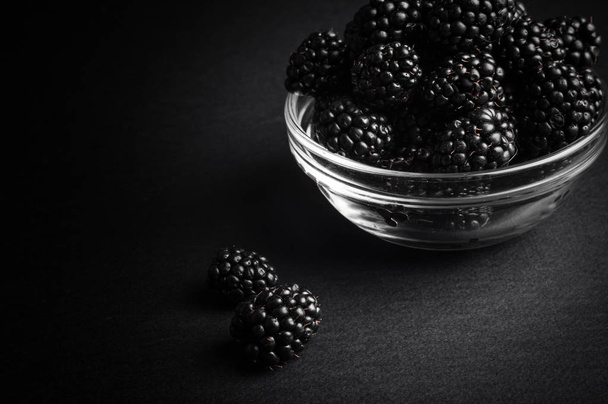 Fresh Ripe Juicy Blackberries in a plate on black background - Fotoğraf, Görsel