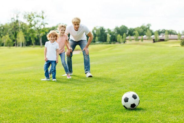 ojciec z dziećmi gry w piłkę nożną w parku - Zdjęcie, obraz