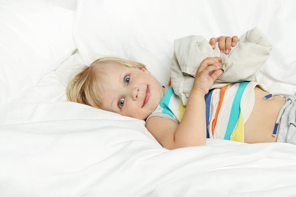 Little boy lying in white bed - Fotoğraf, Görsel