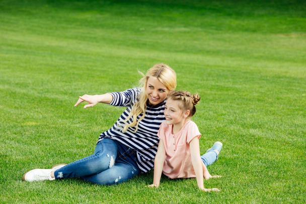 mother and daughter sitting on meadow - Photo, Image