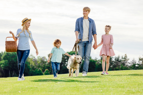 familia con perro paseando en parque
 - Foto, Imagen