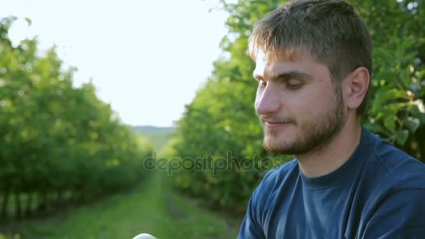 Beautiful guy tastes a green apple - Footage, Video