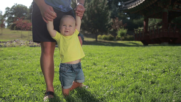 Roztomilé dítě první kroky s pomocí otce - Záběry, video