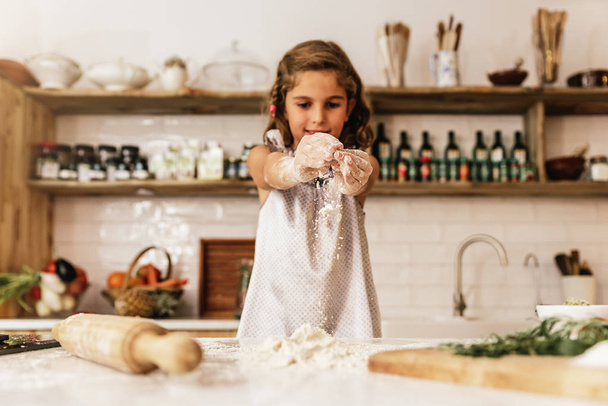 Little child girl kneading dough prepare for baking cookies. - Fotoğraf, Görsel