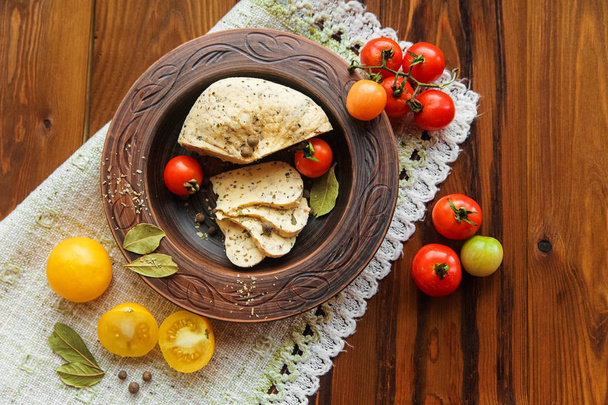 queso casero, tomates con especias de hierbas en alfarería rural.servilleta de mesa.fondo de madera
. - Foto, imagen