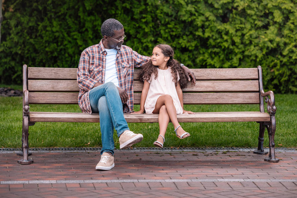 girl and grandfather sitting on bench - Φωτογραφία, εικόνα