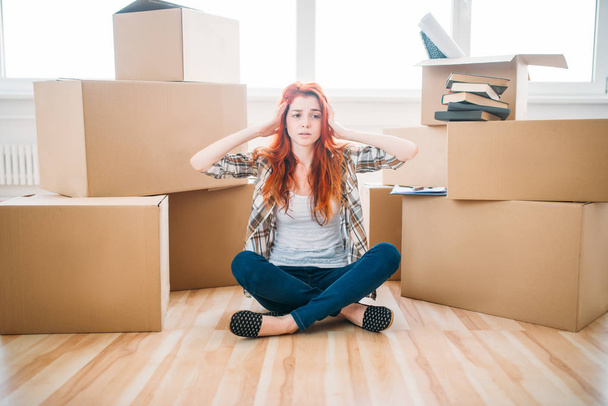 woman sitting near boxes in new apartment - Foto, Imagen