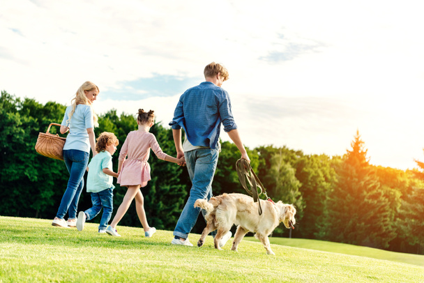 Familie mit Hund spazieren im Park  - Foto, Bild