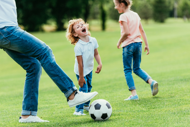 padre con niños jugando fútbol
 - Foto, Imagen