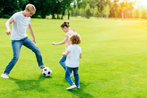 père avec des enfants jouant au football
 - Photo, image