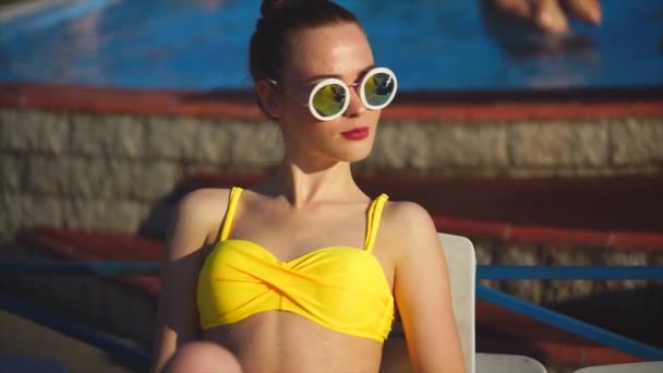 Stijlvolle en jonge vrouw in zonnebril zonnebaden in de zonnige zomer - Video