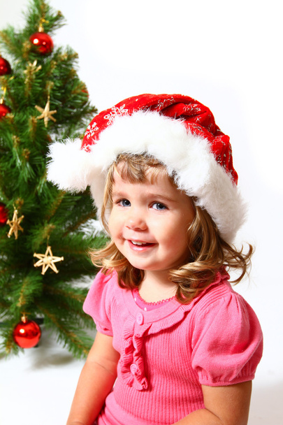 Sweet child near Christmas or New Year tree isolated on white ba - Foto, afbeelding