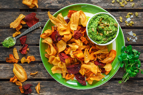 Home made vegetable crisps from carrots, parsnips and beetroot with watercress guacamole - Photo, Image