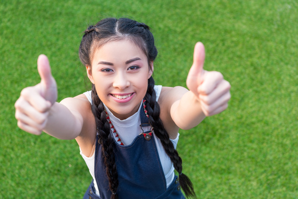 menina asiática mostrando polegares para cima
   - Foto, Imagem