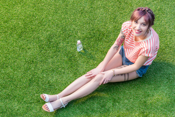 Jovem mulher descansando na grama
 - Foto, Imagem
