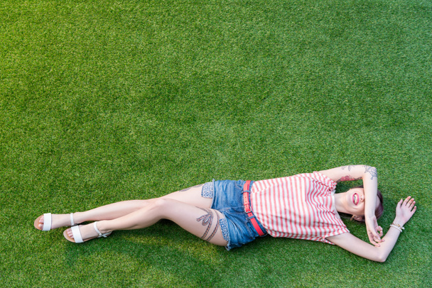 young woman lying on grass - Фото, зображення
