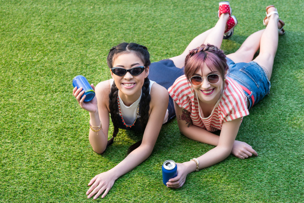 chicas multiétnicas con latas de refresco
 - Foto, Imagen