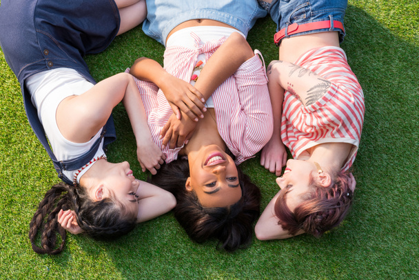multiethnic girls lying on grass  - Fotó, kép
