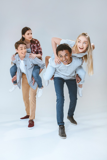 multicultural teenagers piggybacking together - Photo, image