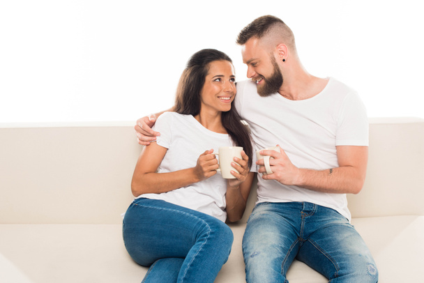 attractive couple on couch with coffee - Фото, изображение