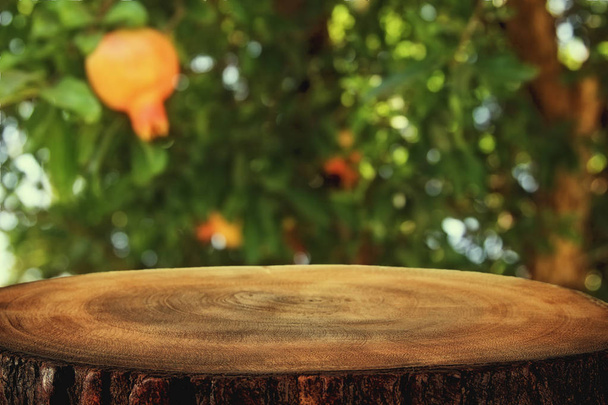 夢のようなザクロの木風景の前にヴィンテージの木製ボード テーブル - 写真・画像