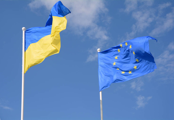 Σημαίες της Ουκρανίας και της Ευρωπαϊκής Ένωσης (ΕΕ) που κυματίζει στον άνεμο - Φωτογραφία, εικόνα