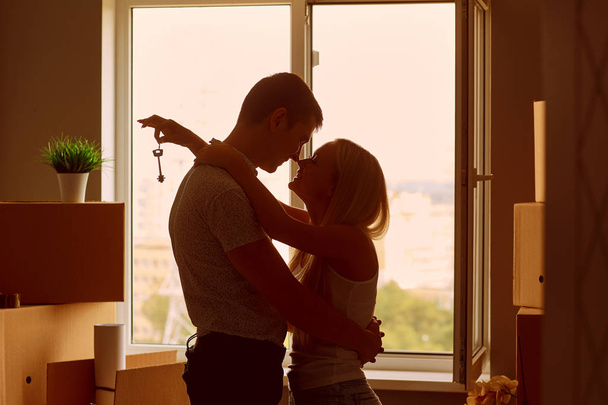 Young couple with keys in new apartment house. - Фото, зображення