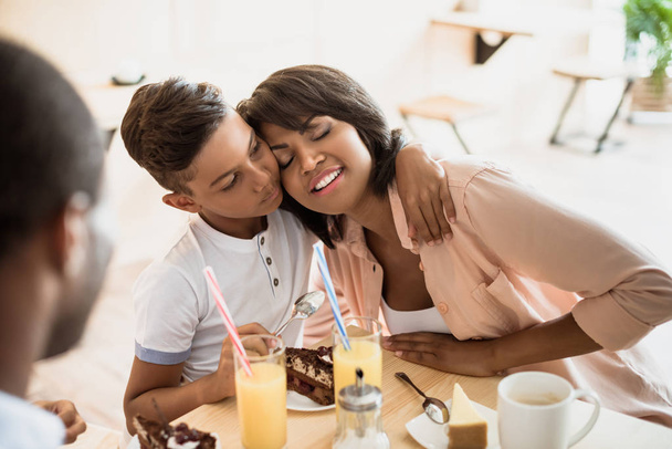 son embracing mother in cafe - Photo, Image