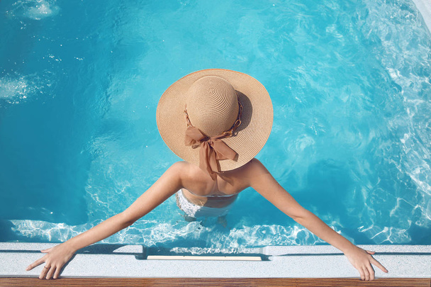 Felülnézet nő a beach kalap élvezi a swimming pool luxu - Fotó, kép