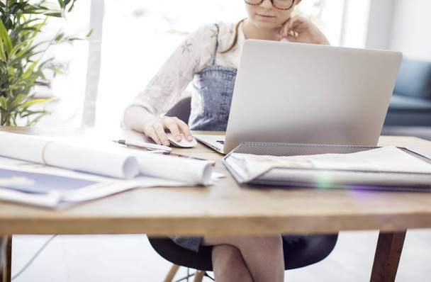 Mujer usando el ordenador portátil mientras trabaja
 - Foto, Imagen