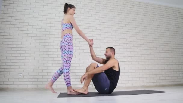 beautiful couple doing acro yoga in studio - Materiał filmowy, wideo