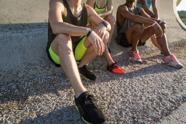 Cropped image of young people in sportswear sitting - Foto, imagen
