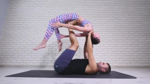 Akrobaattista joogaa. Nuori nainen ja mies suorittavat harjoituksia. Akrobatian ja joogan yhdistelmä
 - Materiaali, video